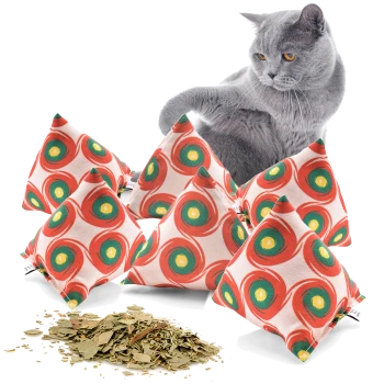 Eine graue Katze untersucht neugierig einen Haufen bunter, mit Katzenminze gefüllter Kissen mit kreisförmigen Mustern, neben losen Katzenminzeblättern.