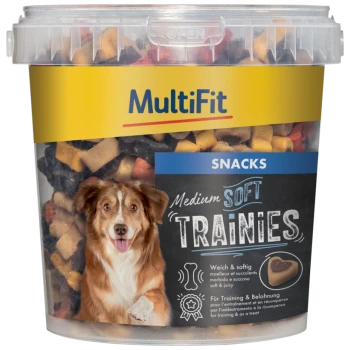 Un conteneur en plastique transparent de friandises pour chiens MultiFit Medium Soft Trainies, avec un chien souriant sur l'étiquette, et des friandises colorées visibles à l'intérieur.