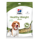 Eine Tüte Hill's Healthy Weight Hundeleckerlis mit einem Beagle, der sich die Lippen leckt, und Text: "Knusprig & Lecker! Unterstützt ein gesundes Gewicht."