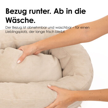 Hände ziehen den Bezug eines beigen Cord-Tierbetts ab; sichtbarer deutscher Text: 'Bezug runter. Ab in die Wäsche.'