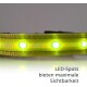 Eine Nahaufnahme eines gelben LED-Hundehalsbandes mit leuchtend grünen LED-Punkten, mit dem Text 'LED-Spots bieten maximale Sichtbarkeit.'