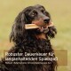 Ein schwarzer Hund kaut auf einem Knochen im Gras, mit Textüberlagerung: "Robuster Dauerkaurer für langanhaltenden Spielspaß" und "Robuster Kauknochen für Spaß."