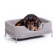 Ein schwarz-brauner Hund liegt bequem in einem modernen grauen Haustierbett mit einem Metallrahmen und zeigt ein gemütliches Design.