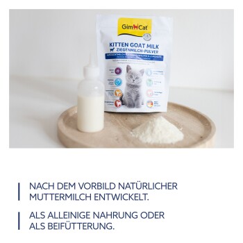 GimCat Kitten Ziegenmilchpulver für Kätzchen 0-2 Monate mit Fütterungsflasche und Pulverhaufen auf Holztablett.