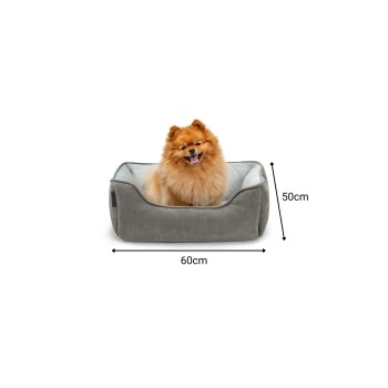 Ein flauschiger Pomeranian-Hund sitzt glücklich in einem grauen Haustierbett, das 60 cm breit und 50 cm hoch ist.