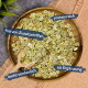 Eine Holzschüssel mit grünen Haferflocken und einem Messlöffel, beschriftet mit "reich an Protein", "ohne Zusatzstoffe", "leicht verdaulich" und "als Ergänzung."