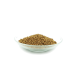 Eine Glasschüssel gefüllt mit kleinen, runden, braunen Haustierfutterpellets, vor einem weißen Hintergrund.