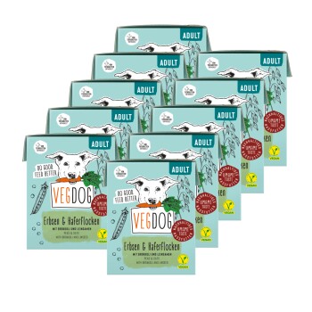 Verpackung für veganes Hundefutter mit einem Cartoon-Hund, der eine Karotte hält, beschriftet mit "VEGDOG Erbsen & Haferflocken" mit Erbsen, Hafer, Brokkoli und Leinsamen.