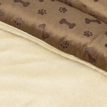 Eine gemütliche Haustierdecke mit einer braunen Oberseite mit Pfoten- und Knochenmustern und einer weichen cremefarbenen Unterseite.