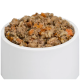 Eine weiße Futterschüssel für Haustiere, gefüllt mit einer Mischung aus Nassfutter für Hunde, mit Fleischstücken und gewürfeltem Gemüse, hauptsächlich orange Karotten.