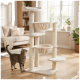 Beige multi-level cat tree with two hammock beds, top perch and scratching posts, tabby cat inspecting it in living room.