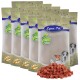 Sechs Beutel Lyra Pet Natural Power Haustierfutter aufgereiht, mit einem Haufen kleiner, roter, würfelförmiger Leckerlis davor.