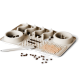 Eine beige Futtermatte für Haustiere mit zwei Schalen, eine spiralförmig gestaltete, texturierte Abschnitte zur Futteranreicherung, verstreute Kroketten und einen Spatel.