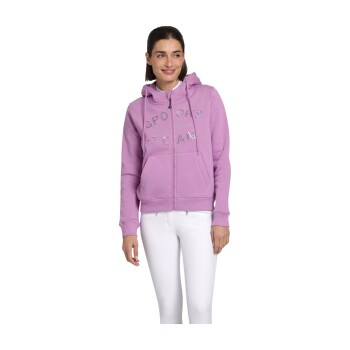 Eine Frau trägt einen helllila Reißverschluss-Hoodie mit dem Text 'SPORTS TEAM' in glitzernden Buchstaben, kombiniert mit weißen Hosen.