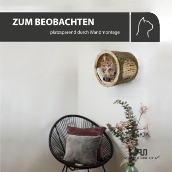 Ein gemütliches, wandmontiertes Katzenbett aus geflochtenem Material, mit einer Katze, die herausblickt, mit dem Text "ZUM BEOBACHTEN platzsparend durch Wandmontage."