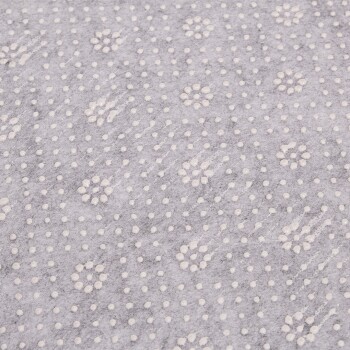 Nahaufnahme eines strukturierten grauen Stoffes mit kleinen weißen Blumenmustern und gepunkteten Designs.