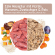 Premium-Zutaten für Haustierfutter ausgestellt: rohes Fleisch, Kürbis, Kastanien, Pflaumen, Reis und Karotten, mit Text auf Deutsch.