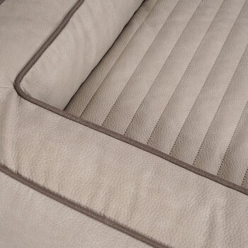 Nahaufnahme eines beigen Haustierbettes mit einem gesteppten Design und kontrastierendem braunen Rand, das seine weiche Textur und den Komfort zeigt.