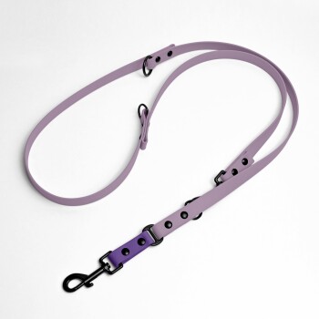 Eine lavendelfarbene Hundeleine mit schwarzen Metallclips und verstellbaren Einstellungen, auf einem weißen Hintergrund präsentiert.