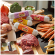 DIBO frische Haustierfutterrollen mit den Etiketten Lamm & Huhn, Rind, Huhn und Pute & Rind mit rohem Fleisch, Gemüse und einem Fleischbeil auf einer Küchenarbeitsplatte.