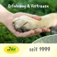 Eine Hand einer Person, die sanft die Pfote eines Hundes auf grünem Gras hält, mit dem Text "Erfahrung & Vertrauen" und "seit 1999" sichtbar.