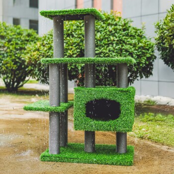 Ein grüner Katzenbaum mit mehreren Ebenen und Kratzpfosten, mit Kunstgras und einem gemütlichen Versteck, im Freien mit Grün im Hintergrund aufgestellt.