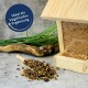 Ein Holzvogelhausfütterer, gefüllt mit Samen, neben einer Schaufel mit getrockneten Blütenblättern, mit dem Text 'Ideal als Vogelfutter-Ergänzung' in einem blauen Kreis.