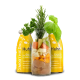 Ein glücklicher Hund leckt eine orangefarbene Flasche mit der Aufschrift 'Smoothie Dog Huhn', während eine Person sie hält, umgeben von grünem Gras.