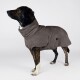 Ein Dobermann trägt einen gemütlichen, grauen Fleece-Hundemantel, sitzt aufrecht und schaut nach oben vor einem schlichten weißen Hintergrund.