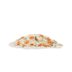 Ein Haufen gemischter Haustierfutterflocken, mit weißen, orangefarbenen und grünen Zutaten, vor einem schlichten weißen Hintergrund.