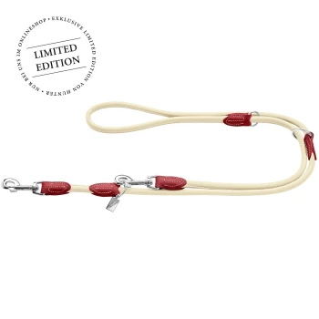 Eine cremefarbene Hundeleine mit roten Lederakzenten und silbernen Metallclips, mit einem "LIMITED EDITION"-Etikett in der oberen linken Ecke.