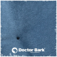 Nahaufnahme eines weichen blauen Stoffes mit einem kleinen schwarzen Punkt, mit dem Logo "Doctor Bark" und dem Text "MADE IN GERMANY."