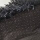 Nahaufnahme einer weichen, flauschigen schwarzen Haustierdecke mit einer strukturierten Unterseite mit kleinen Punkten, ideal für den Komfort von Haustieren.
