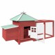 Rotes Holzhaustierhaus mit grünem Dach und einem verbundenen Drahtgehege, mit einer offenen Tür und einem kleinen Eingang.