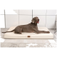 Ein glücklicher grauer Hund, der auf einem cremefarbenen Haustierbett mit einem Holzschild beschriftet mit "tierlando" liegt, vor einem modernen Interieur.