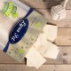 Eine Packung Lyra Nature Power Tierleckereien, mit rechteckigen Leckereien, die auf einer Holzoberfläche verstreut sind, mit einem Seilspielzeug in der Nähe.