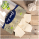 Eine Packung Lyra Nature Power Tierleckereien, mit rechteckigen Leckereien, die auf einer Holzoberfläche verstreut sind, mit einem Seilspielzeug in der Nähe.