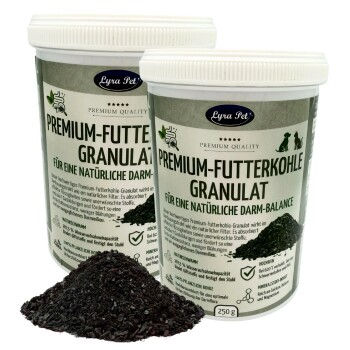 Zwei Lyra Pet-Dosen mit der Aufschrift 'Premium-Futterkohle Granulat' und 'Für eine natürliche Darm-Balance' mit einem Haufen schwarzer Granulate