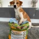 Ein Hund sitzt auf einem Sack mit Premium-Hundefutter, das mit "Hunde-Schmaus" beschriftet ist und Bilder von Zutaten wie Fleisch und Gemüse zeigt.