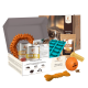 Wildfang Hundegeschenkbox mit Dosenfutter, orangen Kauspielzeugen, Leckerli-Formen und Snacks.