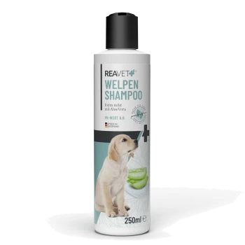 Flasche mit REAVET Welpen Shampoo, 250ml, mit einem Bild eines Golden Retriever Welpen, mit Text, der "Extra mild mit Aloe Vera" und "PH-WERT 6,9" angibt.