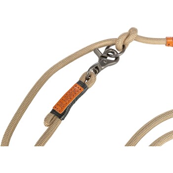 Een close-up van een beige hondenlijn met een metalen clip en een leren label dat 'BE NORDIC' zegt.