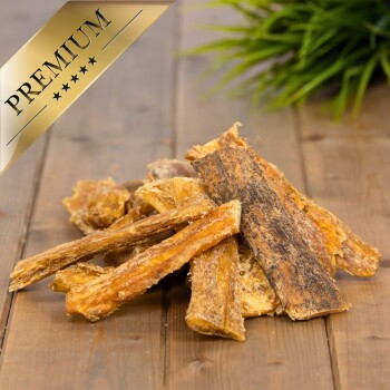 Premium-Haustierleckereien, die auf einer Holzoberfläche präsentiert werden, mit verschiedenen getrockneten Fleischstreifen und einem goldenen "PREMIUM"-Label in der Ecke.