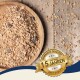 Eine Holzschale mit einer Mischung aus Körnern und Samen auf einer Oberfläche, mit verstreuten Körnern und einem Abzeichen mit der Aufschrift 'Beste Qualität' und '10 Jahre'.