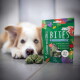 Grüne SmoothieDog Bites Tüte mit gefriergetrocknetem Lamm (SMOOTHIEDOG BITES, LAMM, FREEZE DRIED) und unscharfem Hund im Hintergrund