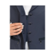 Nahaufnahme einer Hand einer Frau, die den Reißverschluss einer marineblauen Jacke hält, die silberne Druckknöpfe und ein elegantes Design aufweist.