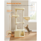 Beiger mehrstufiger Kratzbaum mit hängenden Spielzeugen und Hängematte, Katze dehnt sich auf Holzboden nahe Fenster, deutscher Text über Stabilität und Sicherheit.