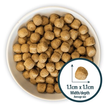 Bowl filled with small, round pet food kibble, average size 1.1cm x 1.1cm, showcasing a light brown color.