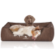 Ein entspannter Hund liegt auf einem braunen Haustierbett mit einem Logo, das "KNUFFELWUFFF" liest. Das Bett hat ein weiches, plüschiges Design.