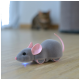 Un jouet souris robotique gris avec des oreilles roses et une lumière bleue lumineuse, posé sur un sol en bois, avec un chat flou en arrière-plan.